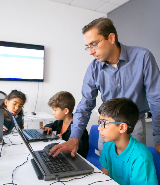 Instructor teaching students on laptop, representing learning professional video editing from scratch
