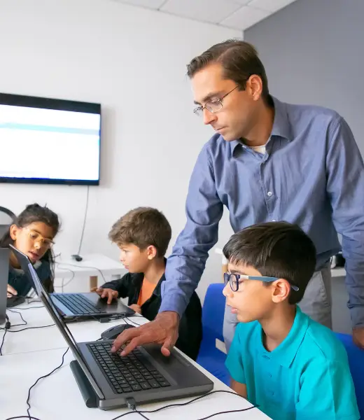 Instructor teaching students on laptop, representing learning professional video editing from scratch