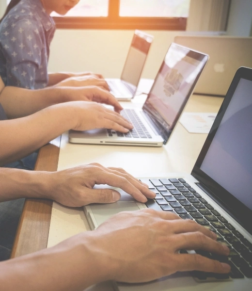 Students practicing typing on laptops during online typing course at Digital Computer Academy